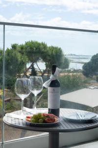 a table with a bottle of wine and two glasses at Ria Formosa Guest House in Faro