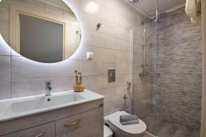 uma casa de banho com um WC, um lavatório e um espelho. em Paxos In Square (Apartment Amfitriti) em Gaios
