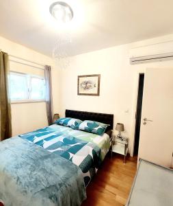 Schlafzimmer mit einem Bett mit einer blauen und weißen Bettdecke in der Unterkunft Apartment Divas Split in Split