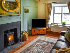 a living room with a fireplace and a television at Enlli in Llanuwchllyn