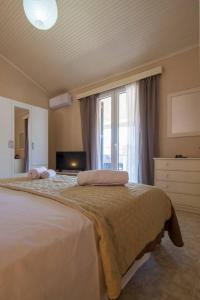 um quarto com uma cama grande e uma janela grande em Paxos In Square (Apartment Amfitriti) em Gaios