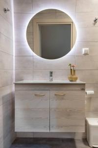 uma casa de banho com um lavatório e um espelho em Paxos In Square (Apartment Amfitriti) em Gaios