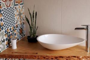 a white bath tub sitting on a wooden table in a bathroom at Casa Emília & Alda in Juncal