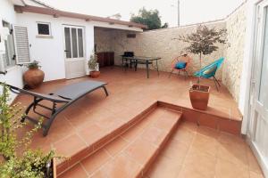 a patio with a bench and a table and chairs at Casa Emília & Alda in Juncal