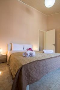 um quarto com uma cama grande com duas toalhas em Paxos In Square (Apartment Amfitriti) em Gaios