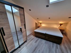 1 dormitorio con cama y espejo grande en DW Castricum, en Castricum