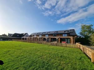 una casa con una recinzione e un campo verde di DW Castricum a Castricum