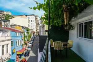 balcón con mesa y sillas en una calle de la ciudad en Taksim Neo Pera Suites, en Estambul