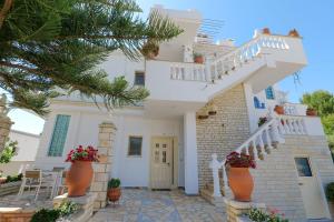 una casa blanca con escaleras y macetas en Vila Vasili, en Ksamil