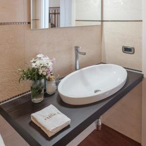 bagno con lavandino bianco e specchio di Fabiola exclusive apartment a Grottaglie