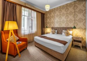 une chambre d'hôtel avec un lit et une chaise dans l'établissement Lacasa Nizami Street, à Baku