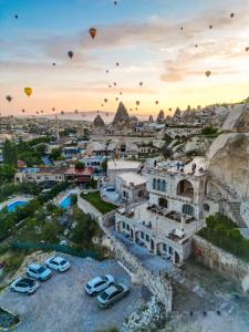 a group of hot air balloons flying over a city at Secret Hill Cave Suites in Goreme