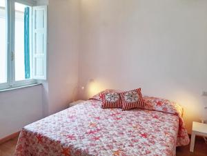 a bedroom with a bed with a red and white comforter at Casa Brezza marina in Marina di Campo