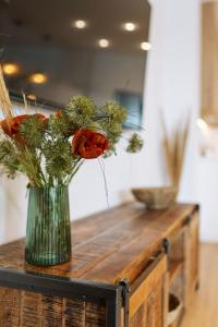 um vaso com flores em cima de uma mesa de madeira em Luxury Suite Flat em La Herradura