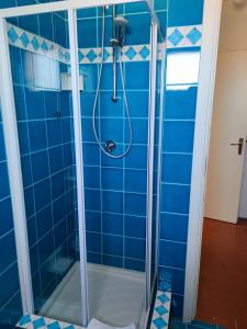 um chuveiro numa casa de banho com azulejos azuis em Casa Pedra Concada em Marinella