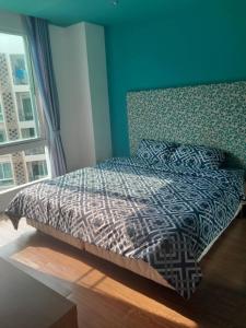 a bed in a bedroom with a blue wall at Atlantis condo G bless in Jomtien Beach