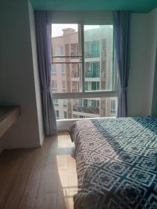 a bedroom with a bed and a large window at Atlantis condo G bless in Jomtien Beach +23 photos
