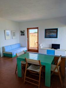 een woonkamer met een groene tafel en een bank bij Casa Pedra Concada in Marinella