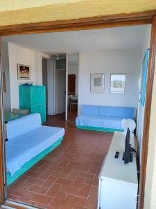 uma sala de estar com dois sofás azuis e uma secretária em Casa Pedra Concada em Marinella