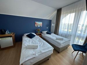 sypialnia z 2 łóżkami i niebieską ścianą w obiekcie Villa REJS Jastarnia w Jastarni