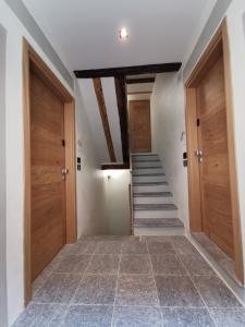 un pasillo con puertas de madera y escaleras en una casa en La Torretta, en Dronero