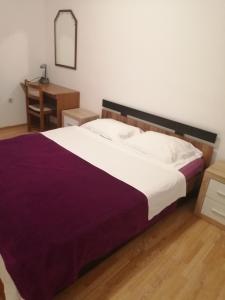 een slaapkamer met een groot bed en een bureau bij Apartments Mirana in Ljubač