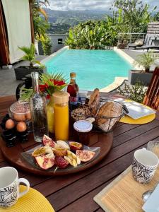 - un plateau de petit-déjeuner sur une table à côté de la piscine dans l'établissement Villa Ti MoOn, Entre deux, Piscine, à Entre-Deux