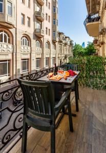 a table with a plate of food on a balcony at Lacasa Nizami Street in Baku
