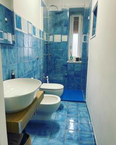 een blauw betegelde badkamer met een wastafel en een toilet bij Acquamarina in Agropoli
