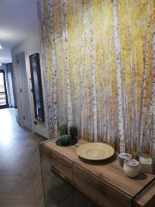 um quarto com uma mesa com uma parede com árvores em Bardonecchia Apartment em Bardonecchia