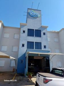 a building with a car parked in front of it at Ribs Hotel in Piumhi