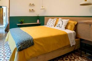 a bedroom with a large yellow bed with pillows at Encantadora casa histórica en la Zona Colonial in Santo Domingo