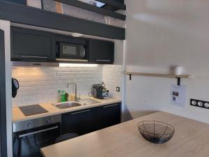 a kitchen with a sink and a counter top at Maisonnette Les Sables in Les Sables-d'Olonne