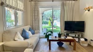 a living room with a couch and a tv at Villa Pineda 5 in Pals