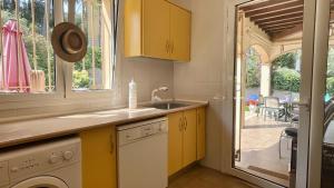 a kitchen with yellow cabinets and a view of a patio at Villa Pineda 5 in Pals