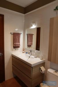 a bathroom with a sink and a mirror and a toilet at VILLAZUL by Villitas in Playa Blanca
