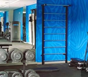 a gym with a blue wall and some weights at Suite - Aqualand Suites in Salinópolis