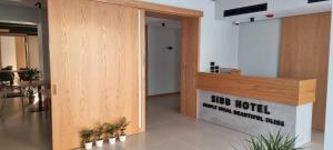 a lobby with a counter with potted plants at SIBB Hotel in Tirana