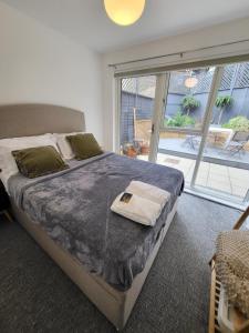 a bedroom with a large bed and a large window at Amazing 5 Stars Home in London