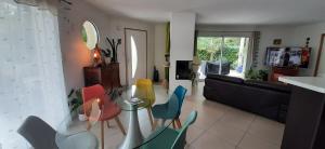 a living room with a glass table and chairs at La Palibe in Tarnos