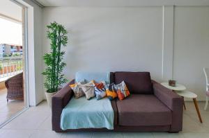 a couch with pillows on it in a living room at Paraíso das Dunas Pé na Areia 2 Suítes 6 Pessoas in Aquiraz