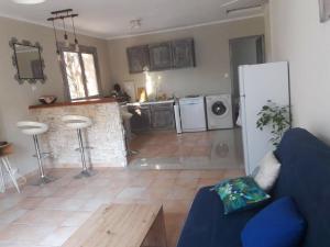 sala de estar con sofá azul y cocina en Charmante maison proche Aix en pce - Spa en Ventabren