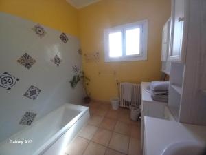 La salle de bains est pourvue d'une baignoire, de toilettes et d'une fenêtre. dans l'établissement Charmante maison proche Aix en pce - Spa, à Ventabren