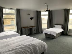 a bedroom with two beds and a window at Churchill's Hotel in Wombwell