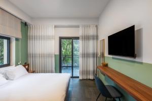 a bedroom with a bed and a flat screen tv at Domus Carmel Hotel in Haifa