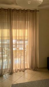 a window with white curtains in a room at Anna-Apartment in Nea Moudania