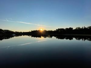 a large lake with the sun setting in the background at Yacht / Hausboot Linssen GS 40.9 AC Abuela in Maasbracht