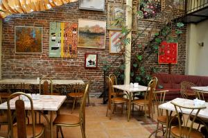 um restaurante com mesas e cadeiras e uma parede de tijolos em Hotel Irena em Lviv
