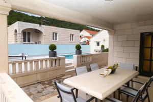 a patio with a table and chairs on a balcony at Insula Apartment with Private Pool in Pučišća