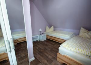 two beds in a room with purple walls and wooden floors at Ferienhaus Lilly in Hain